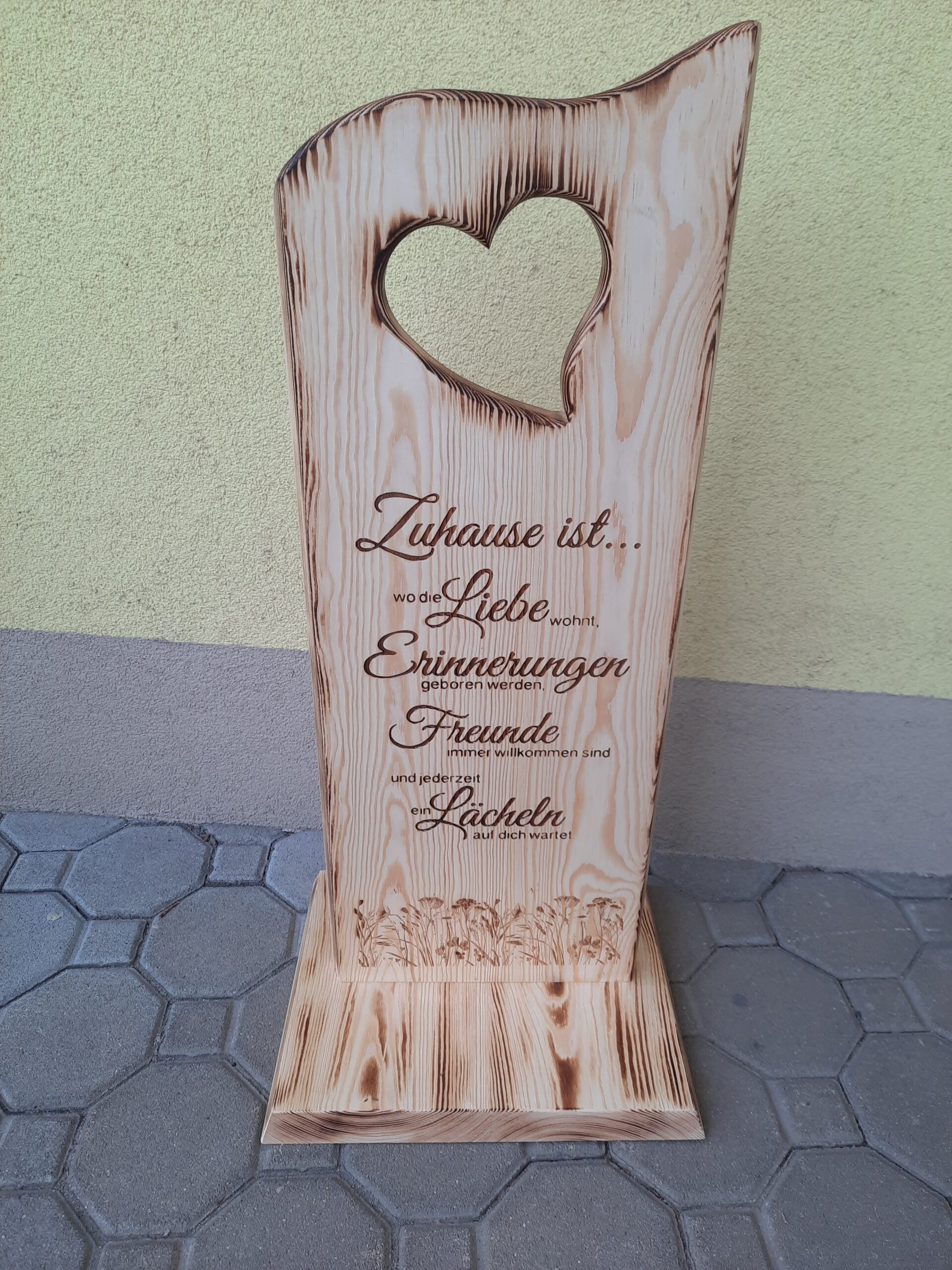 Holzsteher mit ausgeschnittenen Herzen und Zuhausespruch