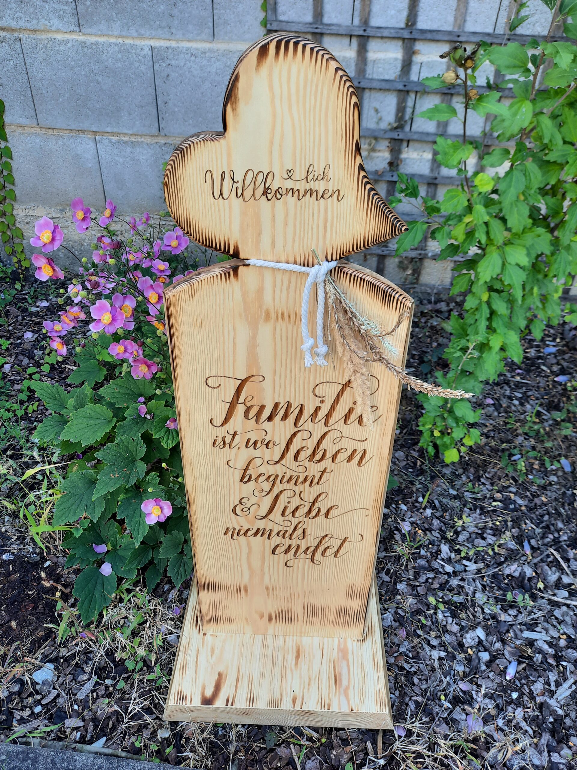 Holzsteher mit aufgesetzten Herzen und Familienspruch