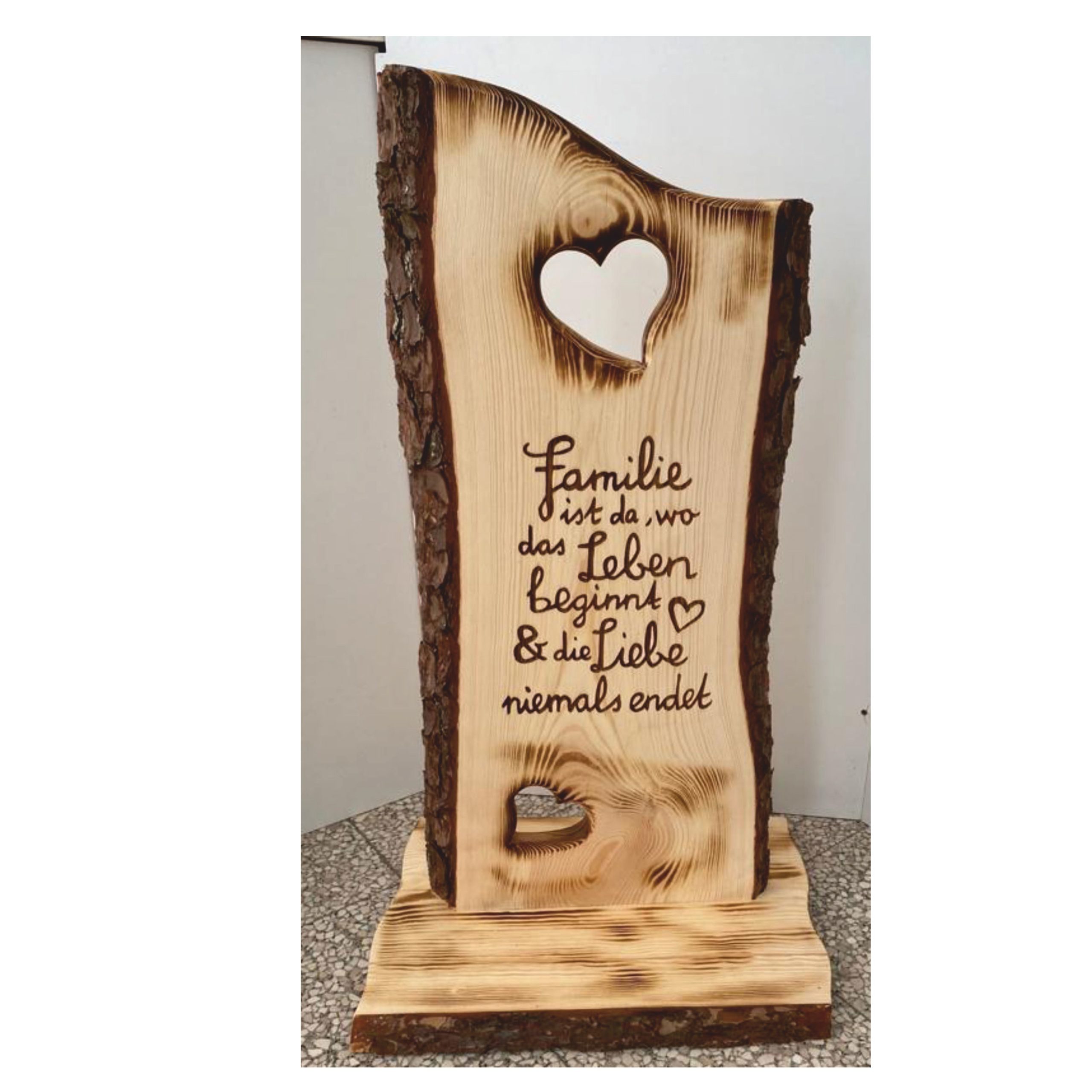 Holzsteher mit ausgeschnittenen Herzen und Familienspruch