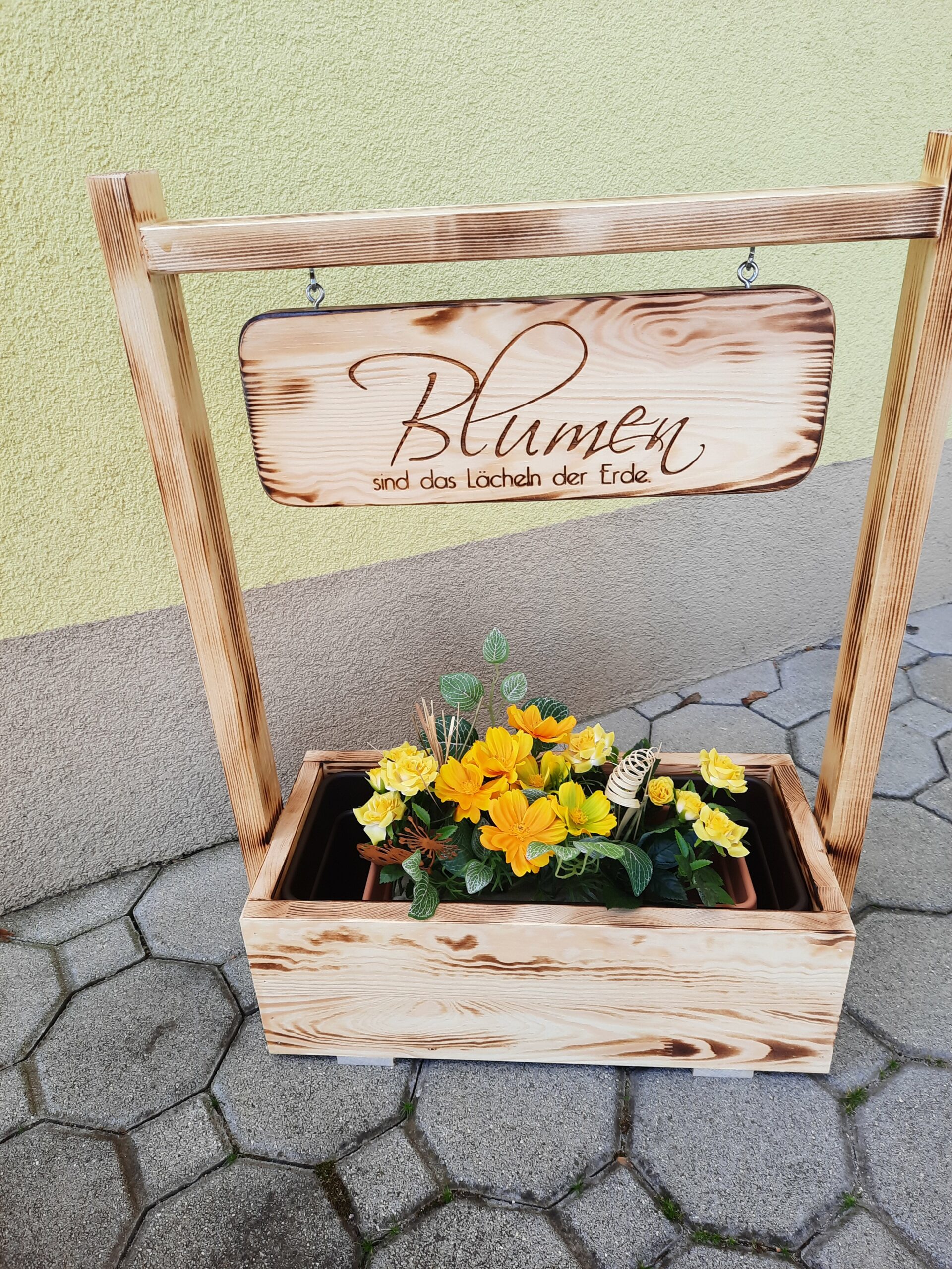 Holzaufsteller mit Blumenkisterl und Schild Blumen sind das Lächeln der Erde