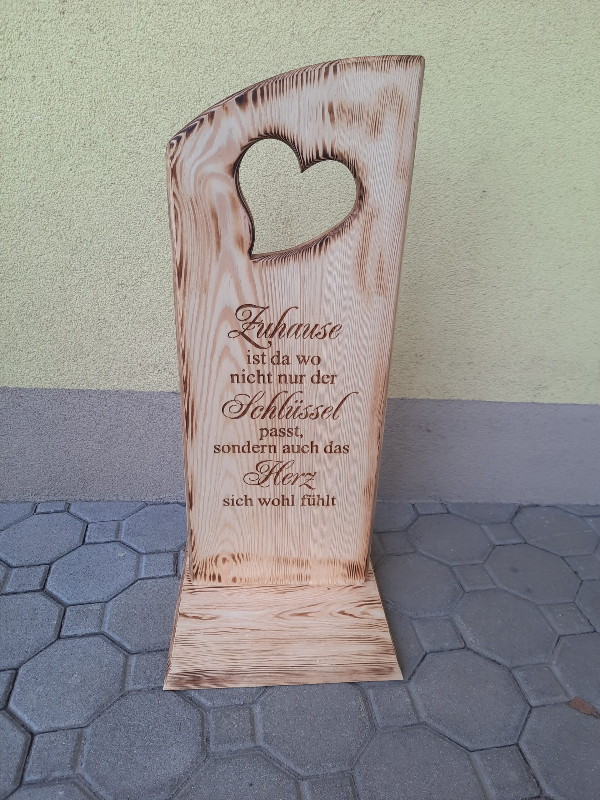 Holzsteher mit ausgeschnittenen Herzen und Zuhausespruch