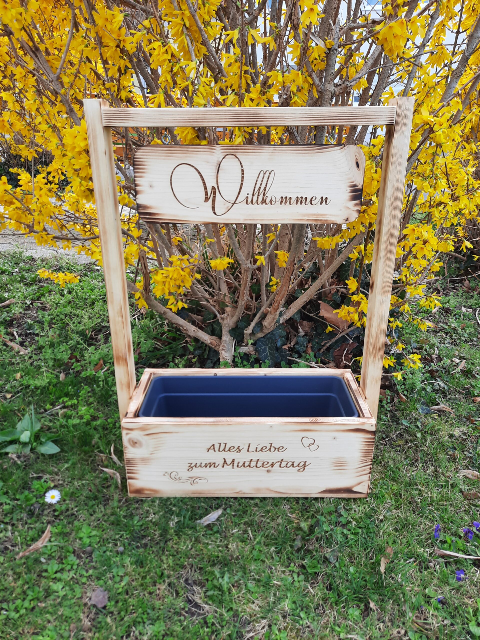 Holzaufsteller mit Blumenkisterl und Schild Willkommen + Alles Liebe zum Muttertag